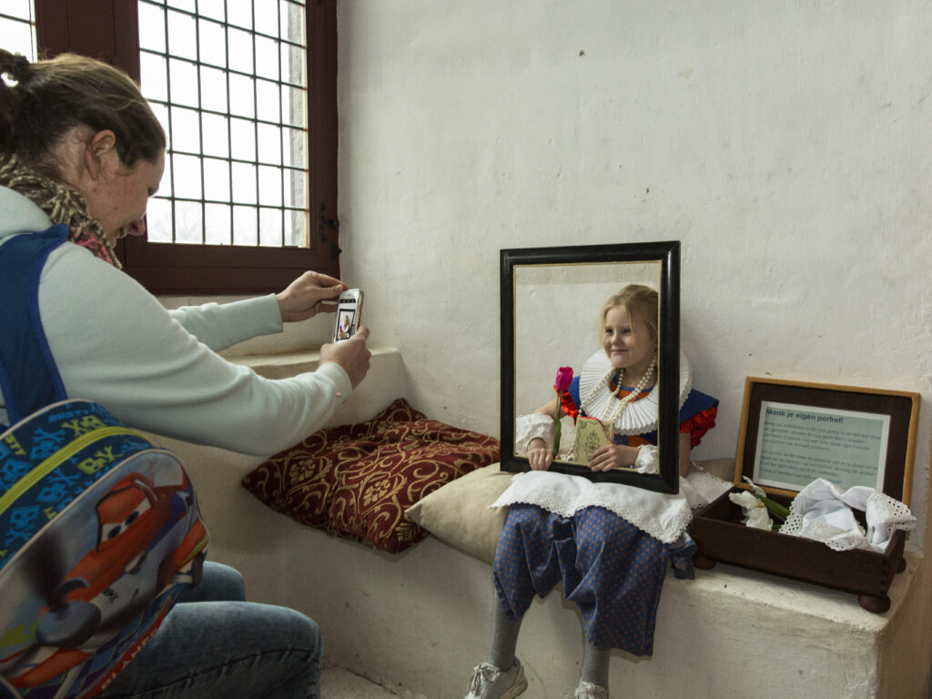 Kind verkleed als middeleeuws meisje wordt op de foto gezet