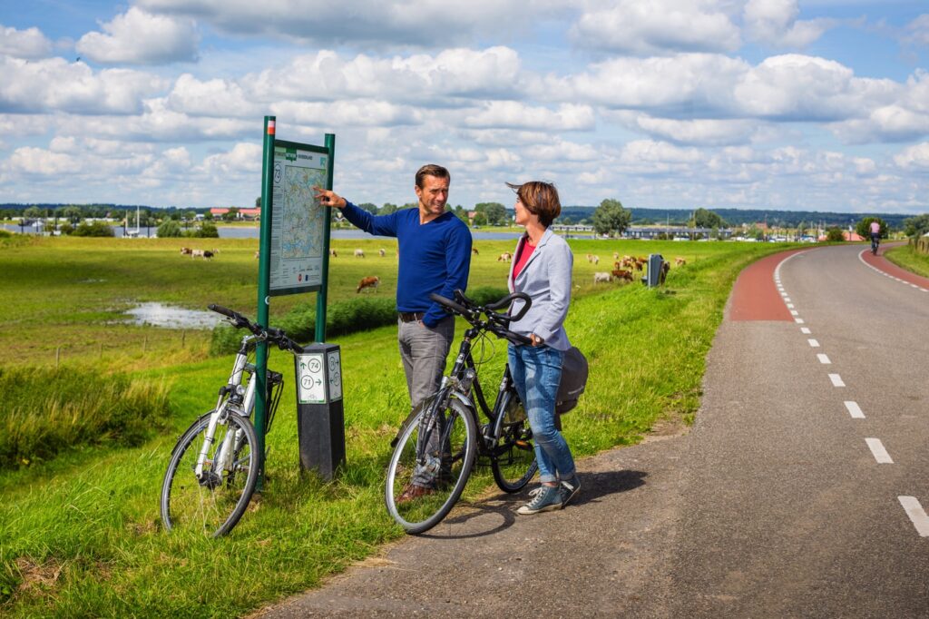 twee mensen met fietsen bij bord knooppuntennetwerk
